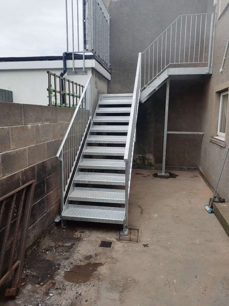 Galvanised fire escape staircase with landing installed in Harrington near Workington Cumbria